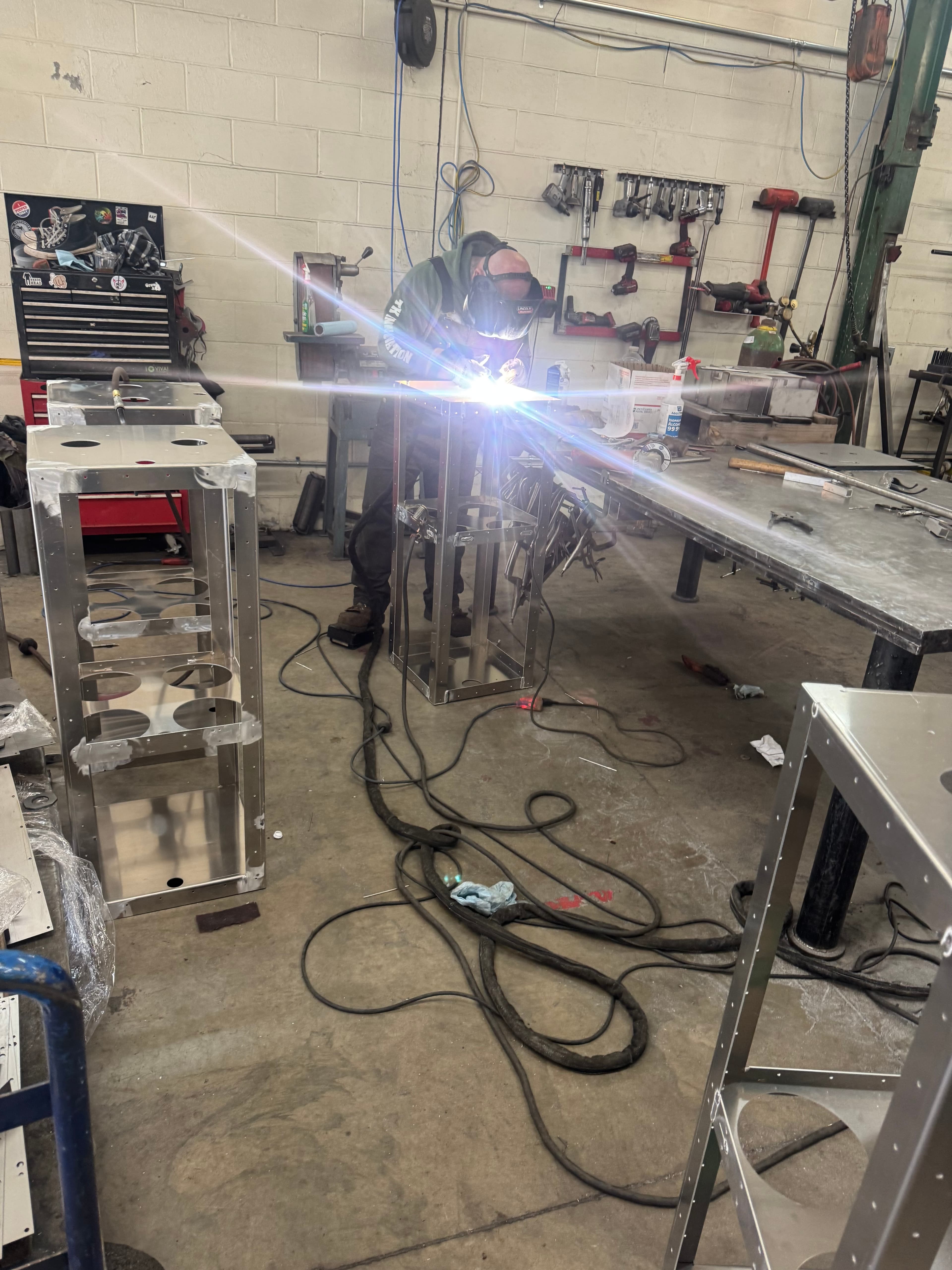Welder at work with arc flash on the SquareVac shop floor